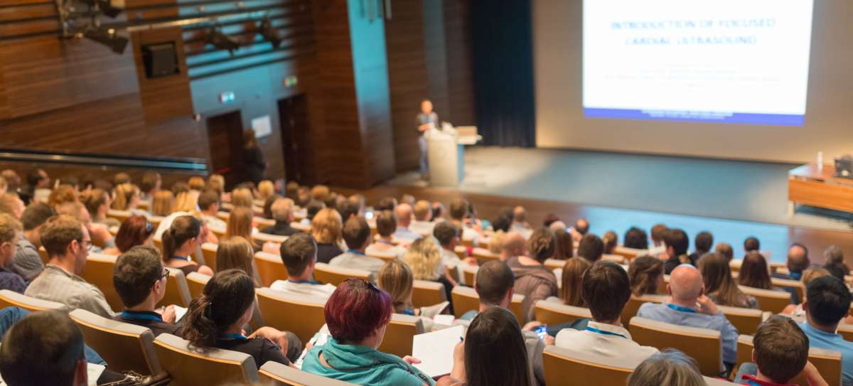 Speaker giving a talk on scientific conference. Audience at the conference hall. 